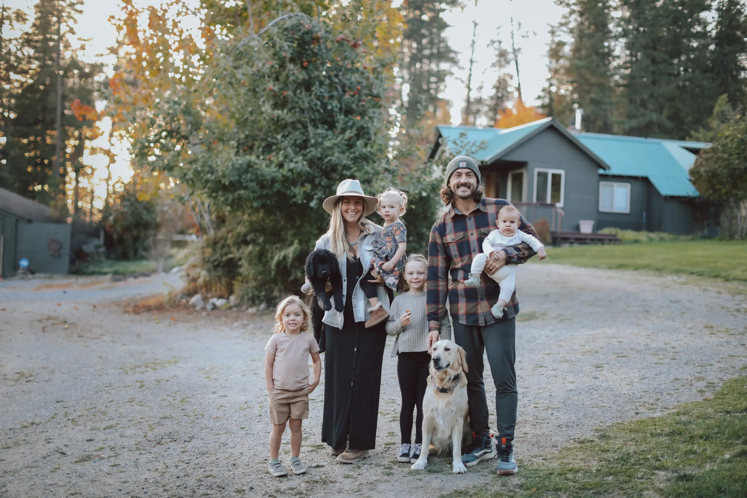 The Aliff family standing together outdoors with their children and dogs